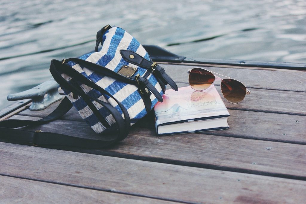 Imagen de un libro con un bolso y unas gafas.