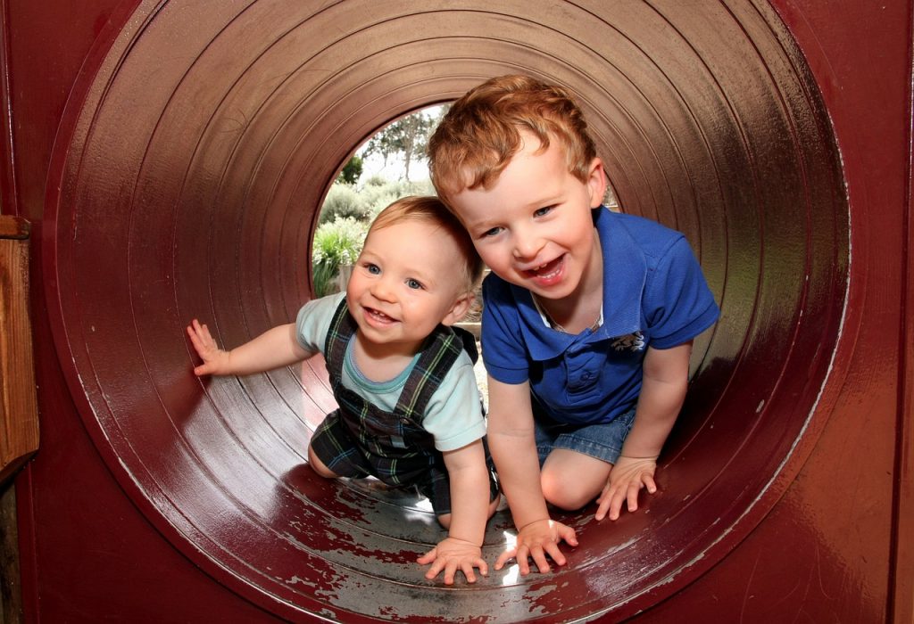 Niños jugando en un tubo del parque